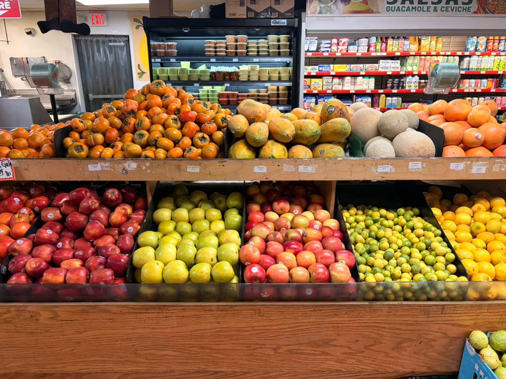 Fruit stand: persimmons, papayas, cantaloupes, apples, pears, limes and oranges
